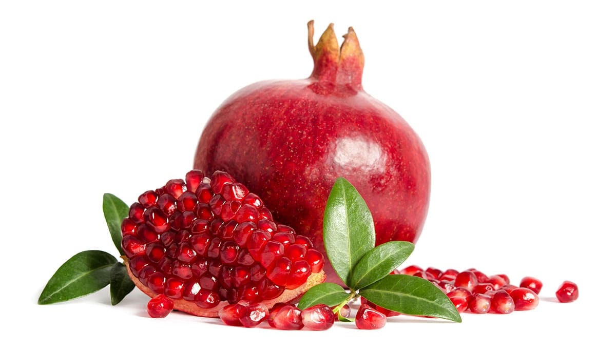 Pomegranate and seeds on a white background.
