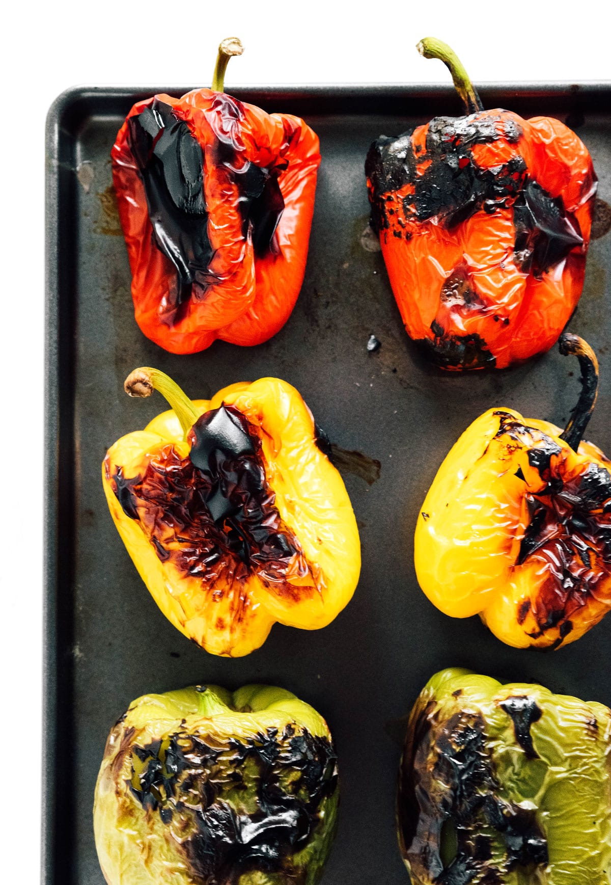 Roasted bell peppers on a baking tray.