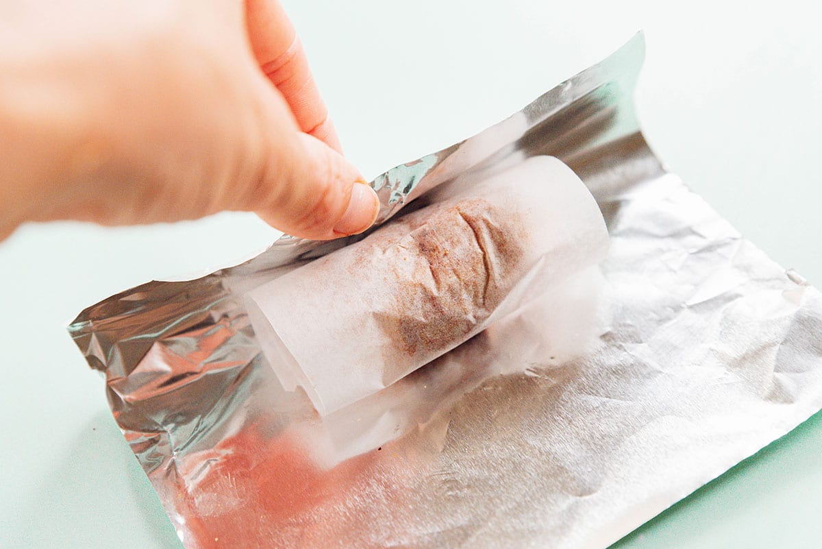 Wrapping vegan sausage mixture in parchment and foil.