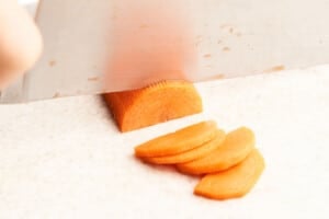 Cutting carrots into half moons.