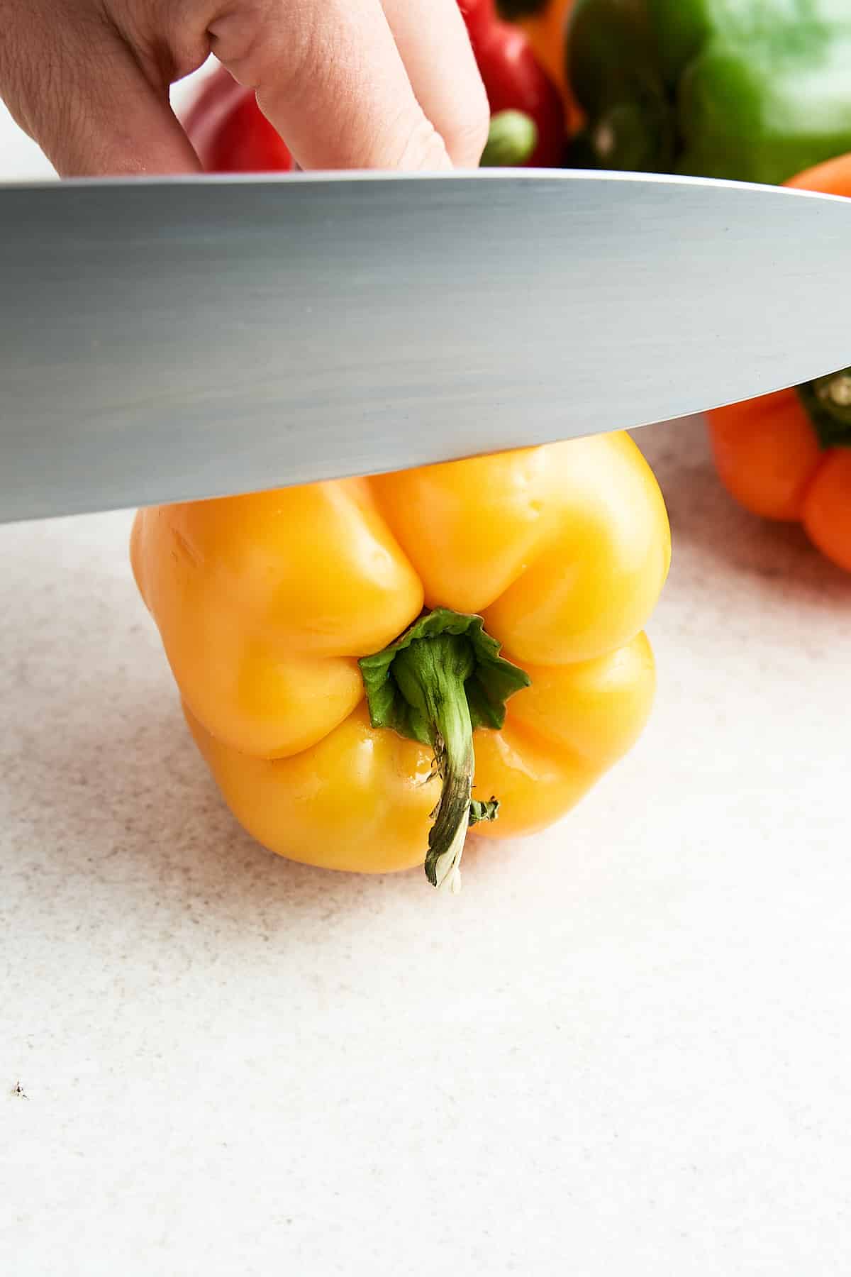 Trimming the top off a bell pepper.