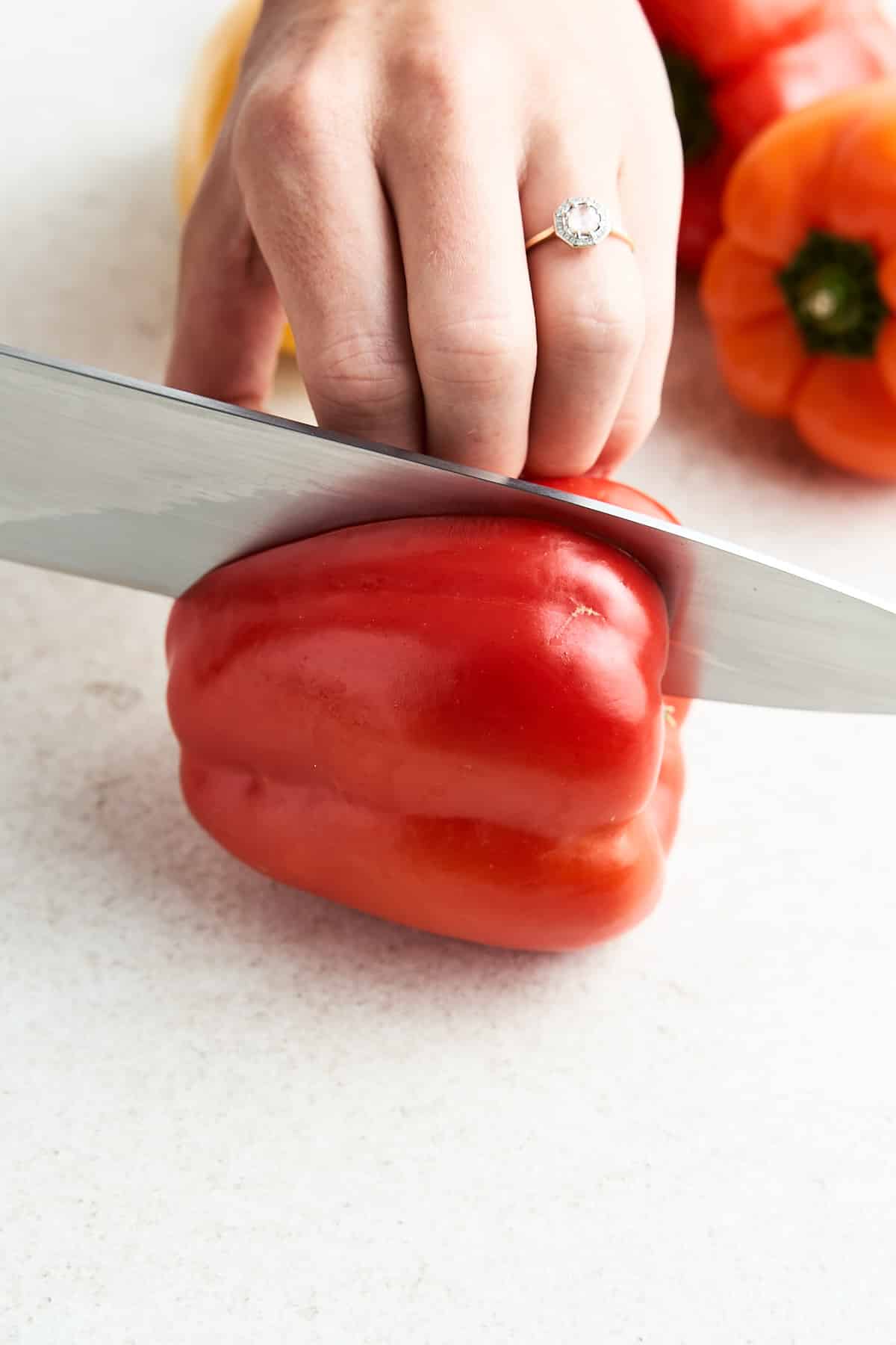 Cutting a bell pepper in half.