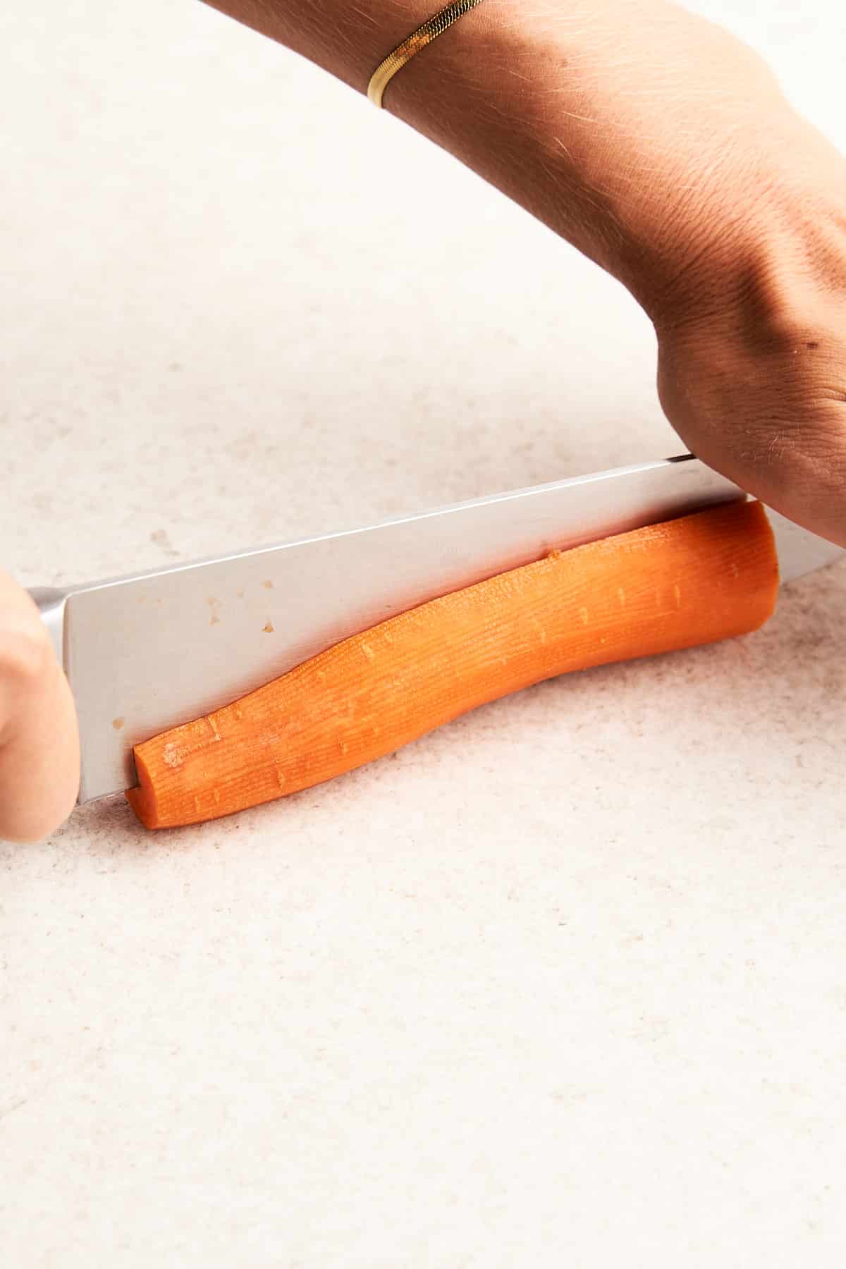 Cutting a carrot in half lengthwise.