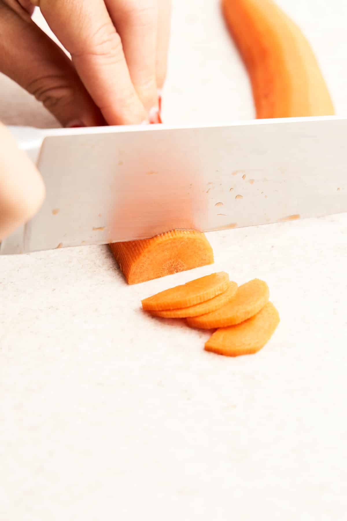 Cutting a carrot into half moons.
