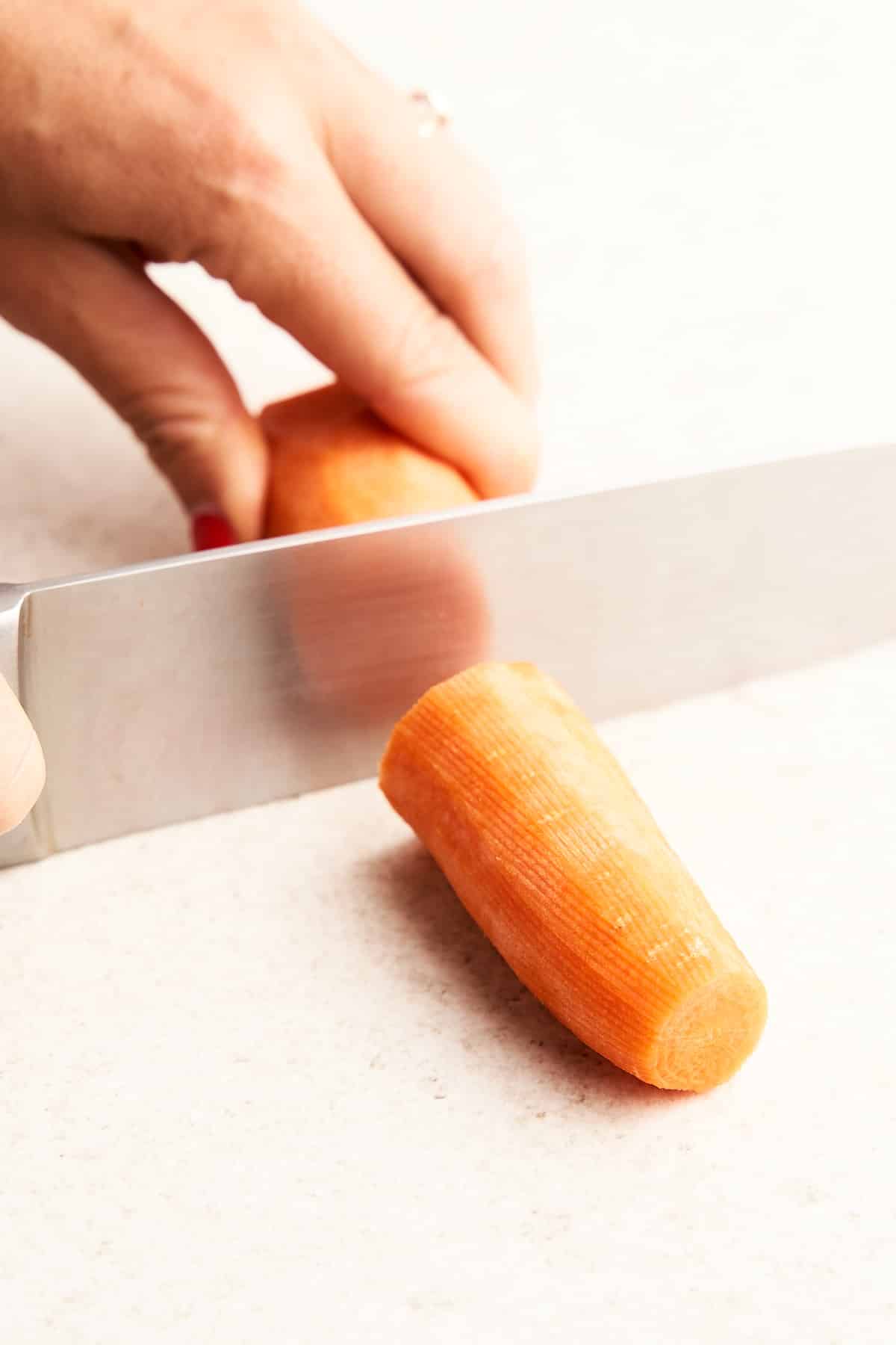 Cutting a carrot into chunks.