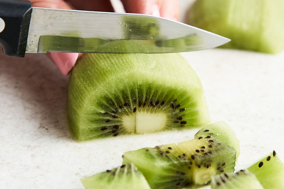 Lay the kiwi on its side (I usually separate a section so the kiwi is on a flat side). Make crosswise cuts about 1/4-inch thick.