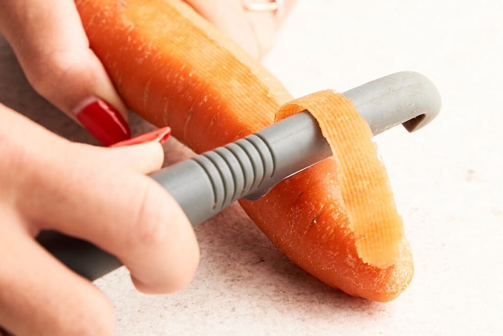 Peel: You have two options for carrots — scrubbing or peeling. Either way, give them a good wash. Then, use a vegetable peeler to remove the skin if you’d prefer.