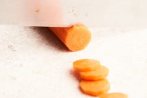 Cutting carrots into rounds.