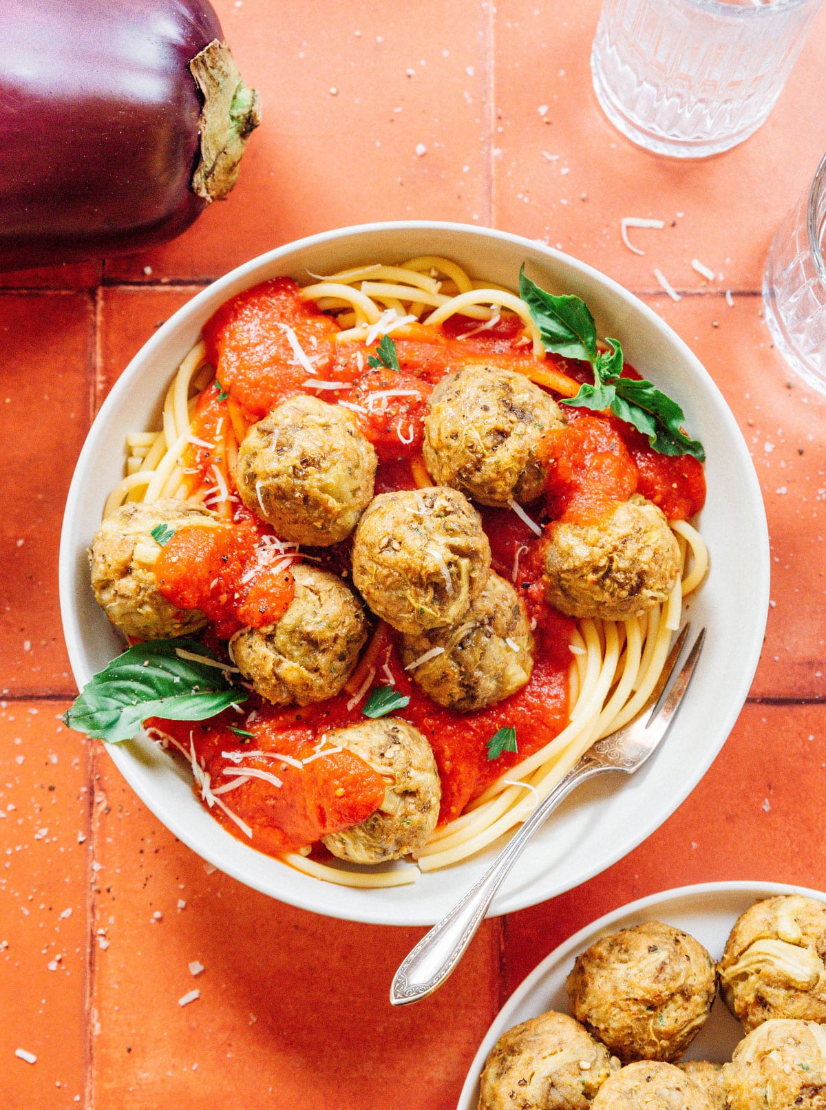 Large white bowl of spaghetti and red sauce topped with eggplant meatballs.