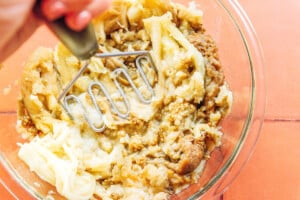 Mashing eggplant in a bowl.