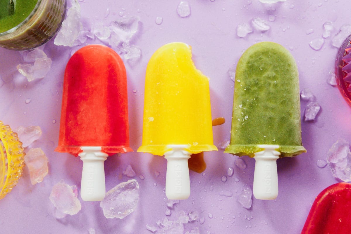 Colorful popsicles on a purple backdrop.