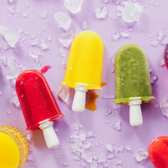 Colorful popsicles on a purple backdrop.