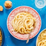 Miso pasta in a red bowl with fork.