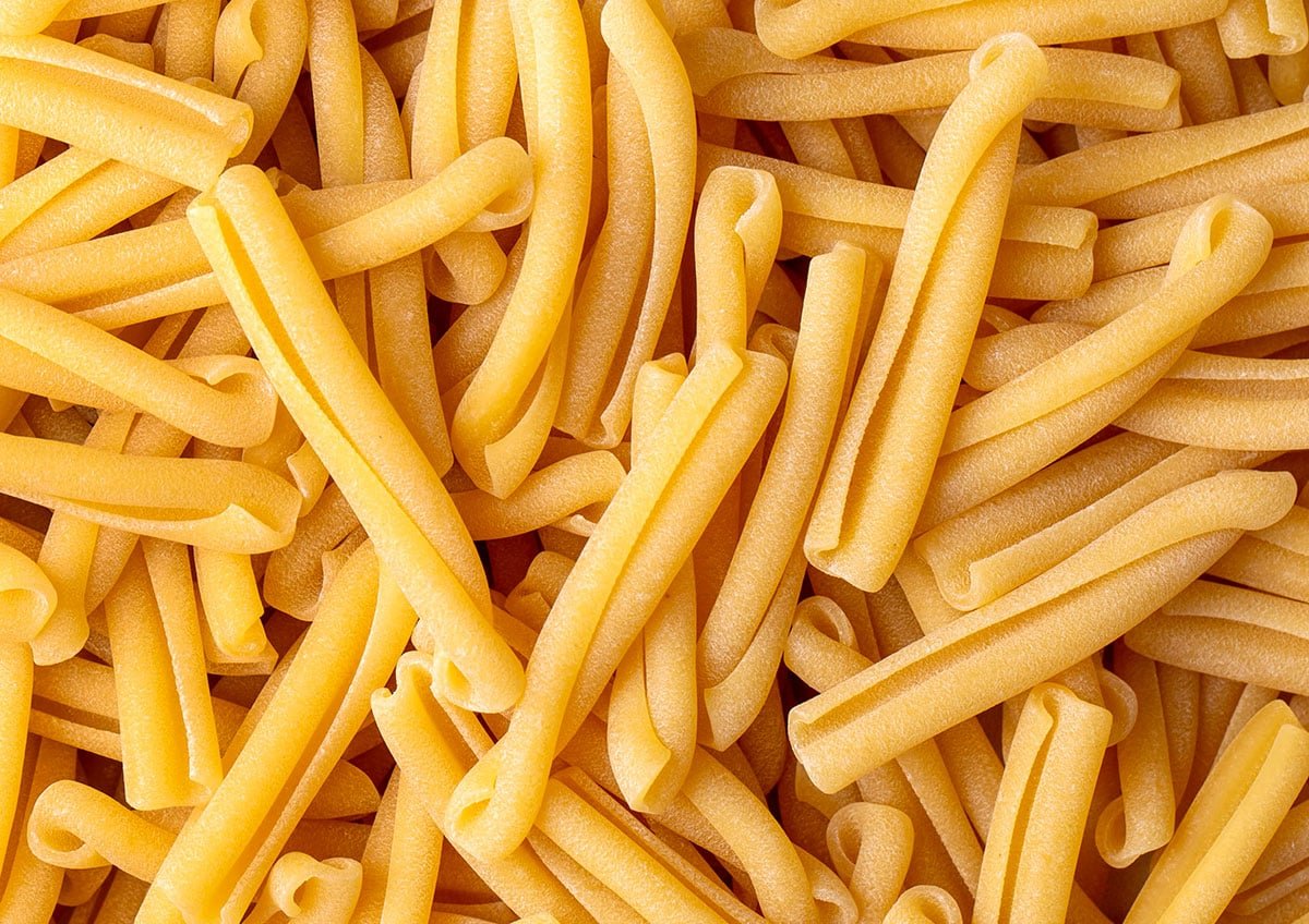 Casarecce pasta on a white background. 