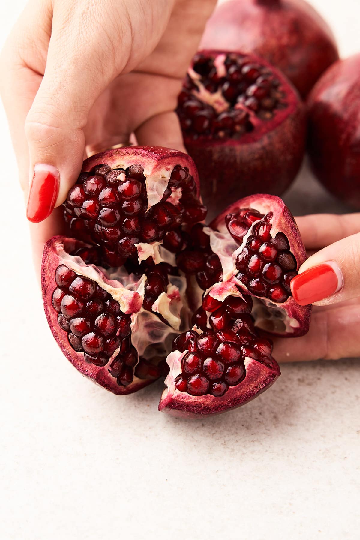 Pulling pomegranate sections apart.