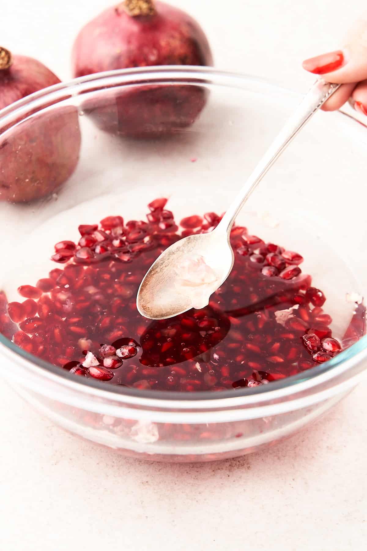 Scooping pomegranate membranes out of water.