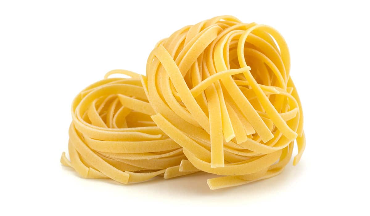 Tagliatelle pasta on a white background. 