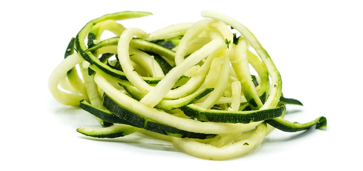 Zucchini noodles on a white background. 