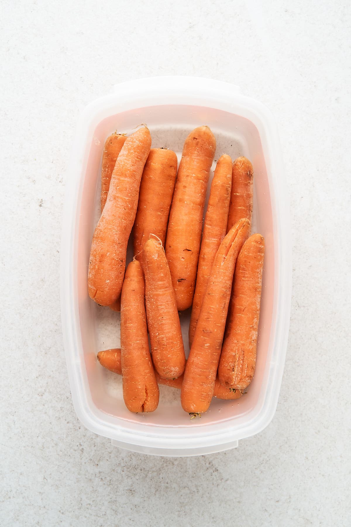 Whole carrots in a container of water.