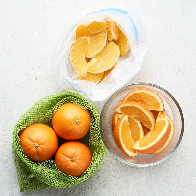 Oranges in a mesh bag, glass container, and plastic bag.