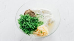 Dill yogurt sauce in a glass bowl.