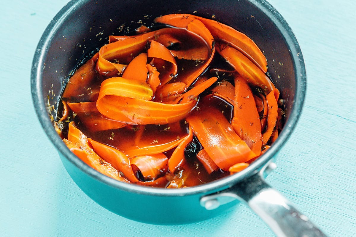 Carrots in a pot of brine with seasonings.