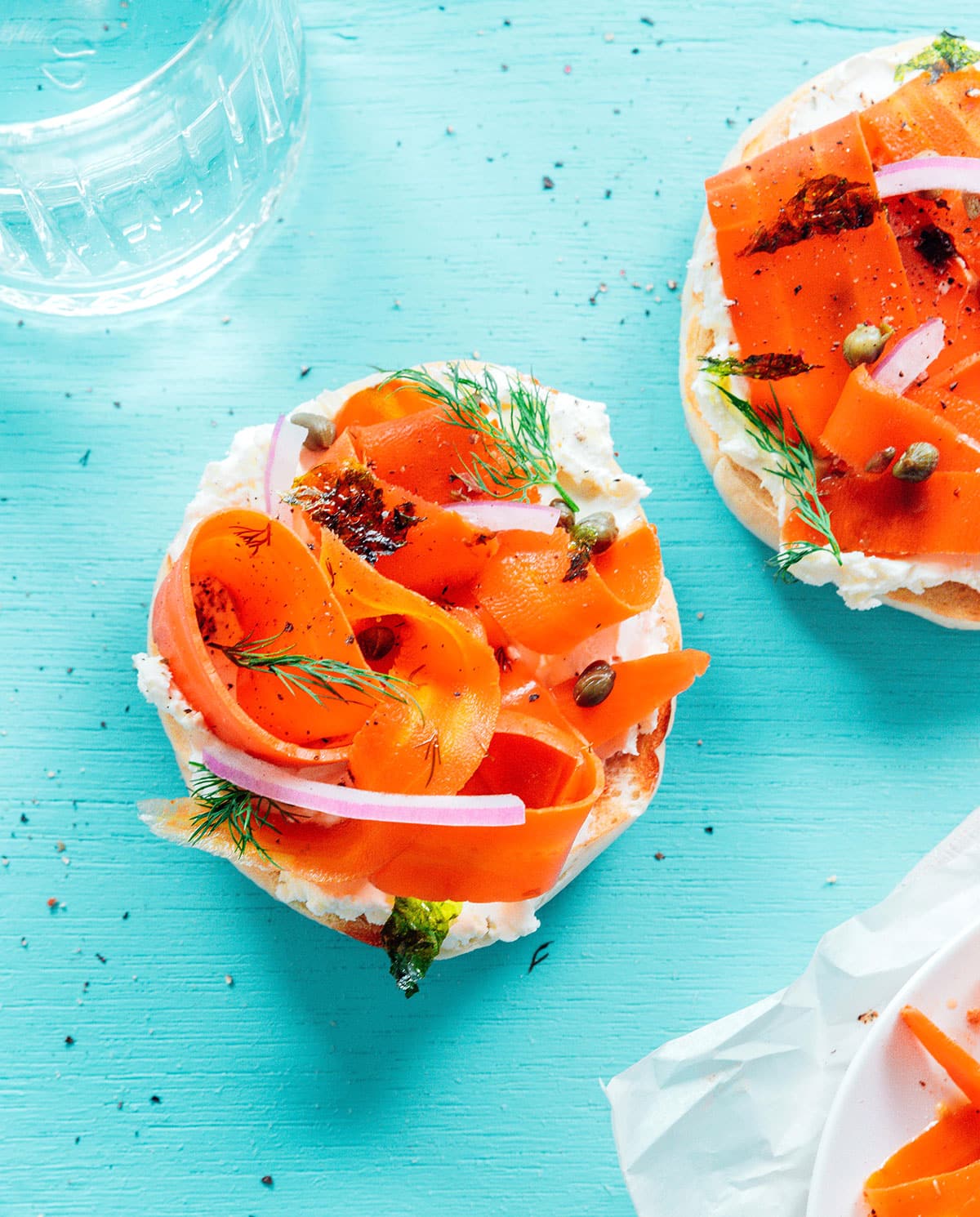 Bagel with cream cheese, carrot lox, capers, and red onions.