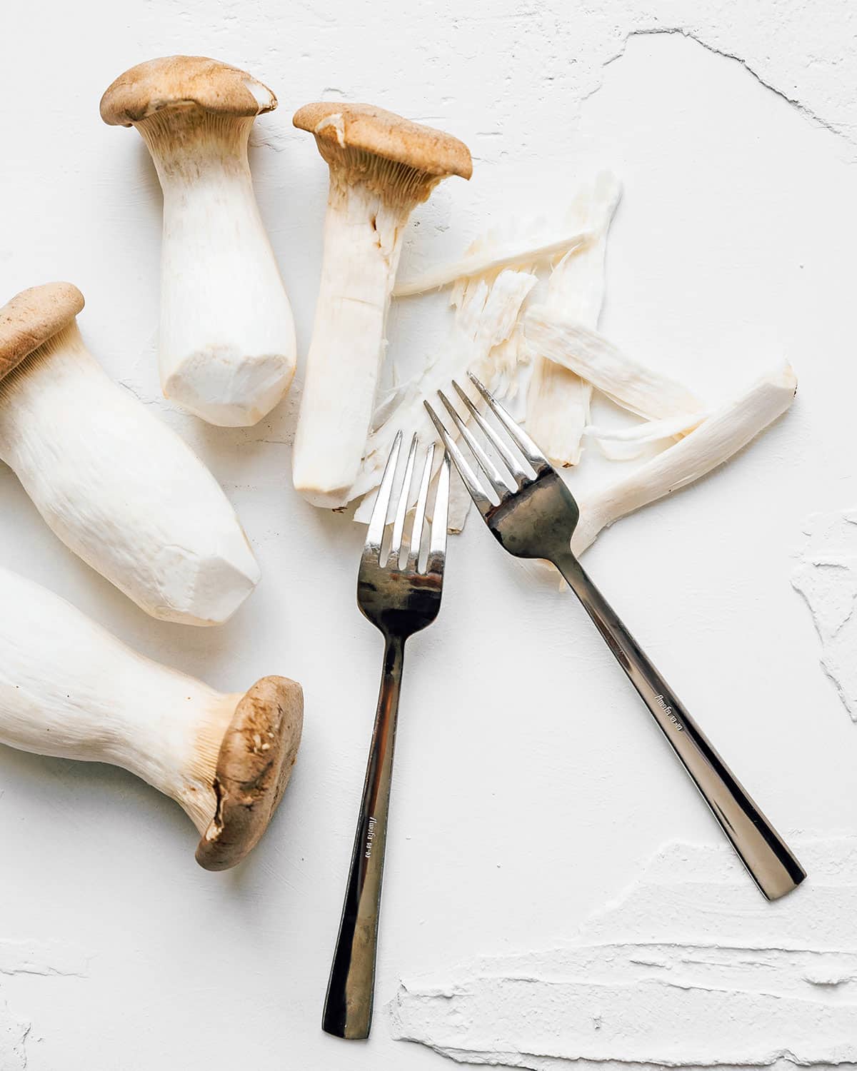 Shredding king oyster mushrooms with forks