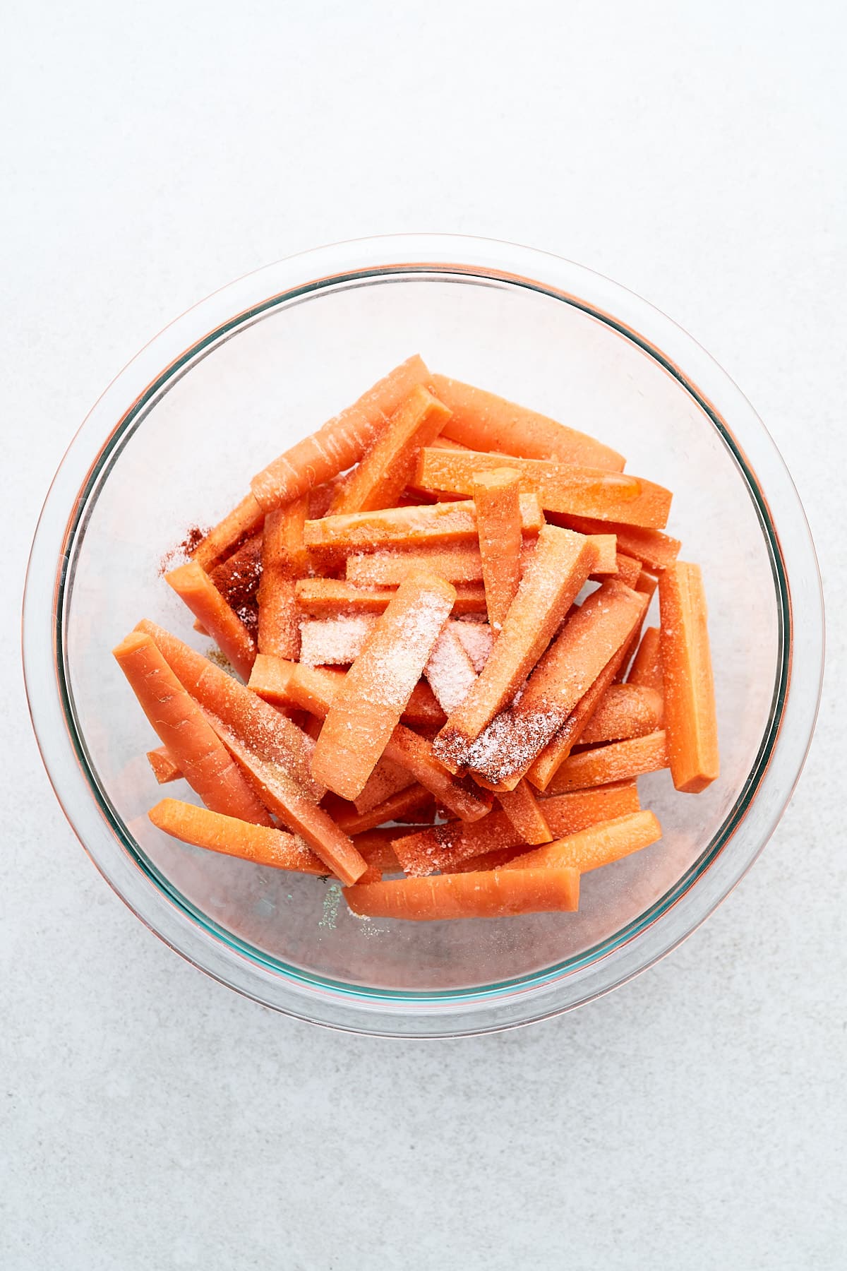Carrot sticks and seasonings in a bowl.