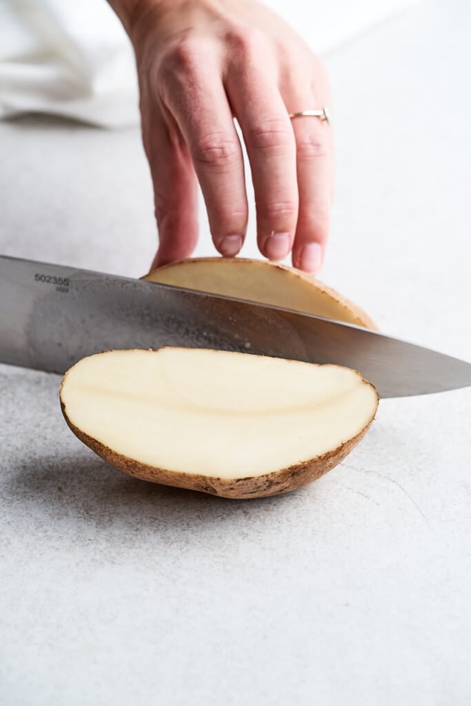 Slicing a potato in half.