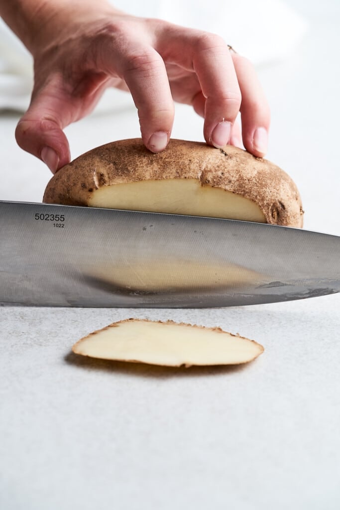 Slicing the end off of a potato.