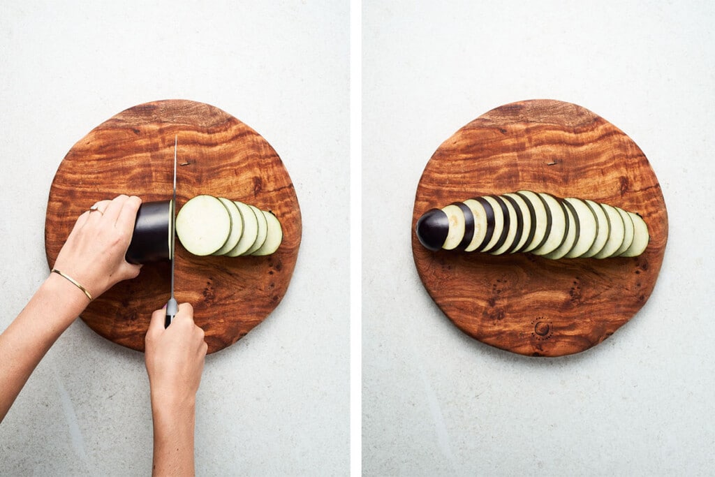 Slicing eggplant into rounds on a wooden cutting board.