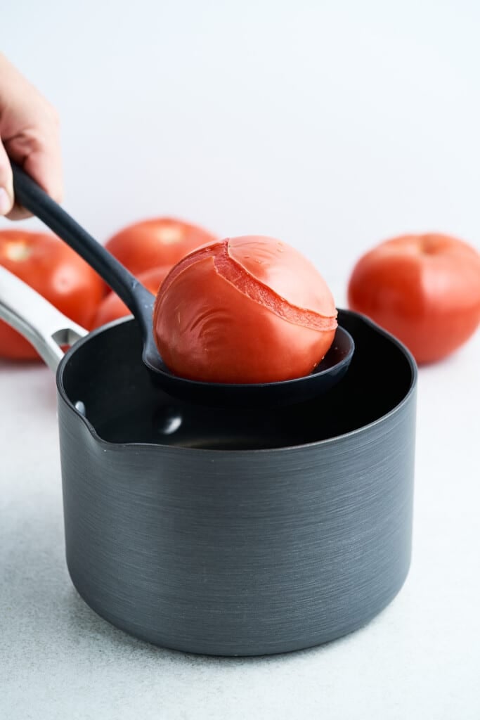 Removing a tomato from a pot.