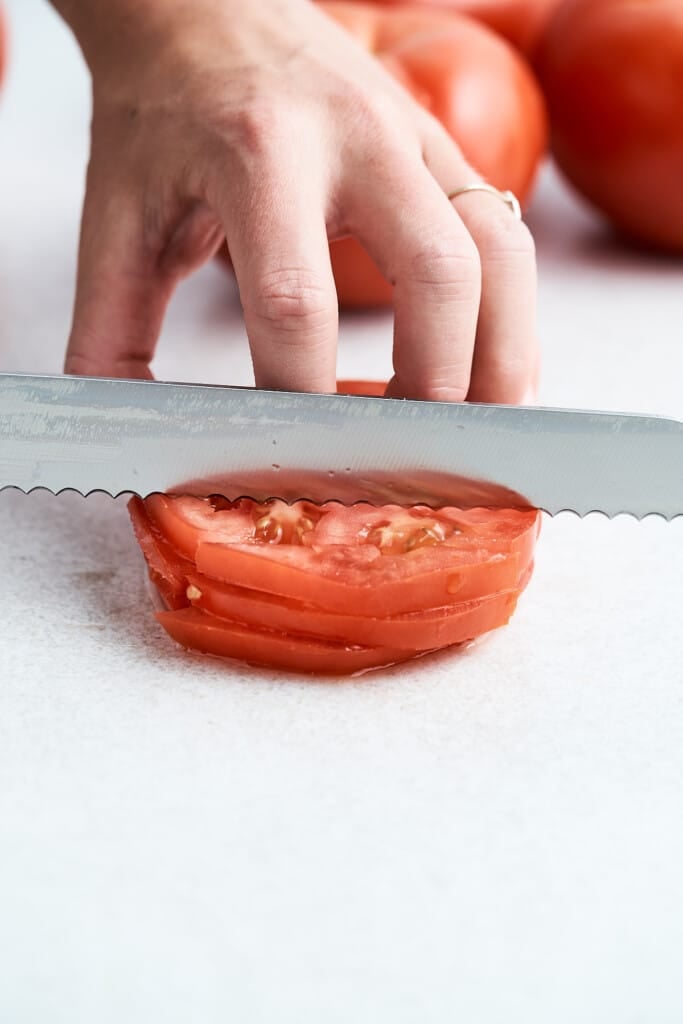 Cutting tomato slices into strips.