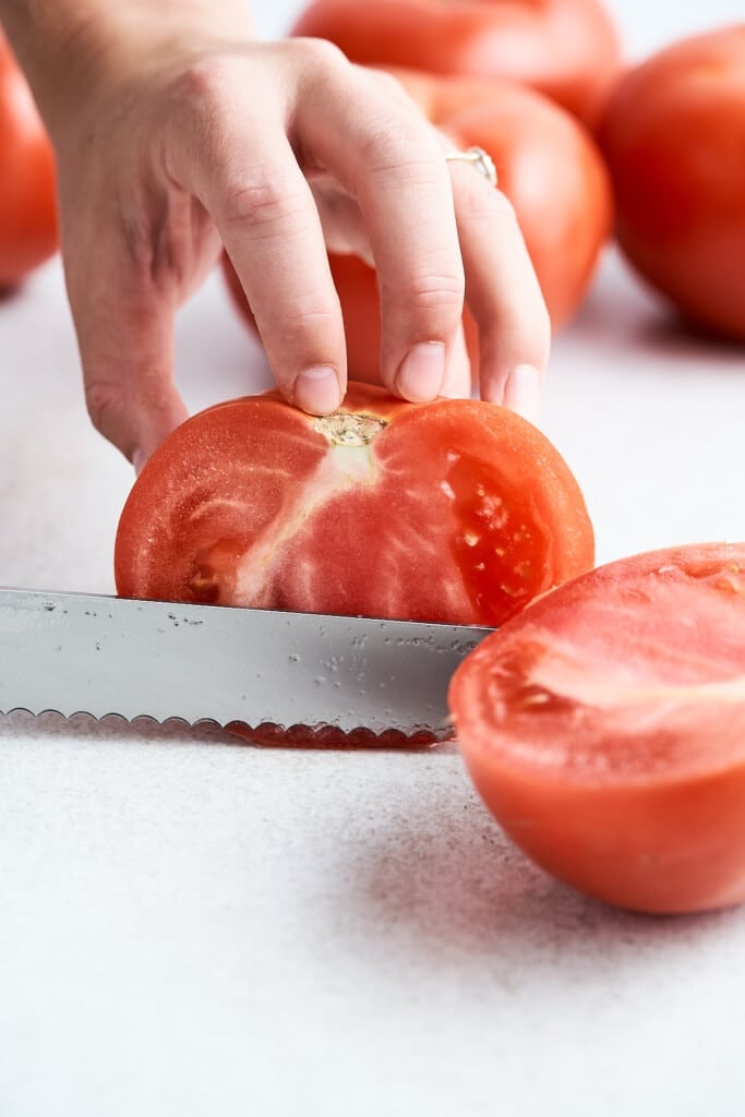 Cutting a tomato in half.