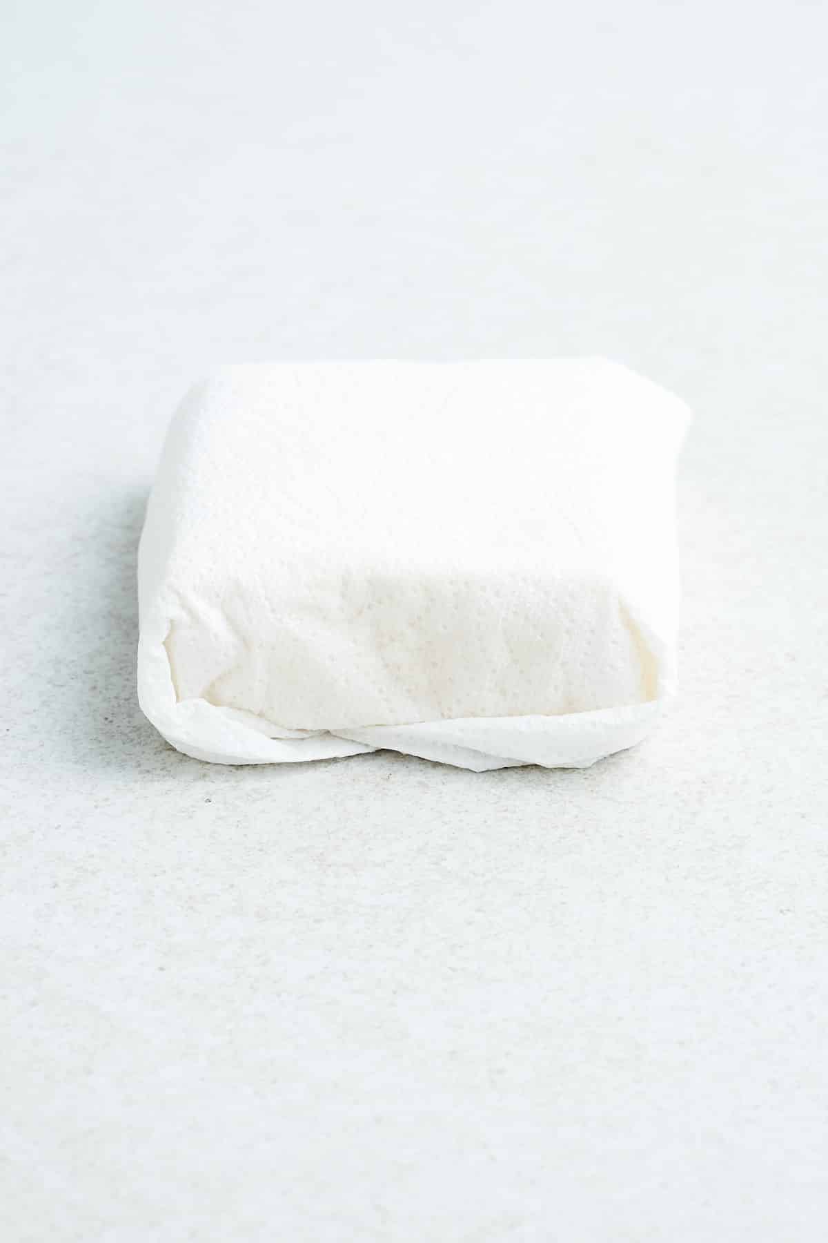 Tofu wrapped in a paper towel.