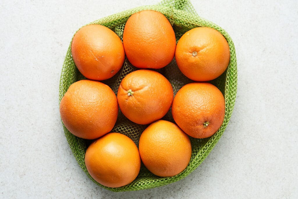 Whole oranges in a mesh bag.