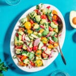Avocado salad on a plate with a serving spoon.