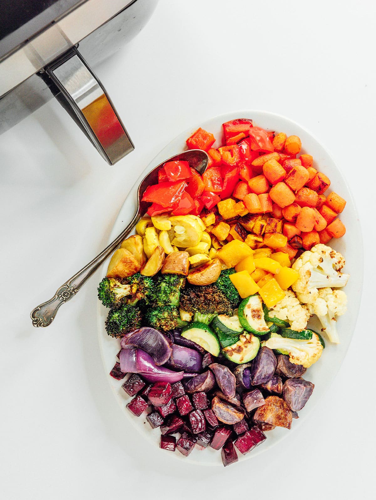 Rainbow vegetables on a platter with an air fryer.