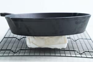 Pressing tofu using a cast iron skillet.