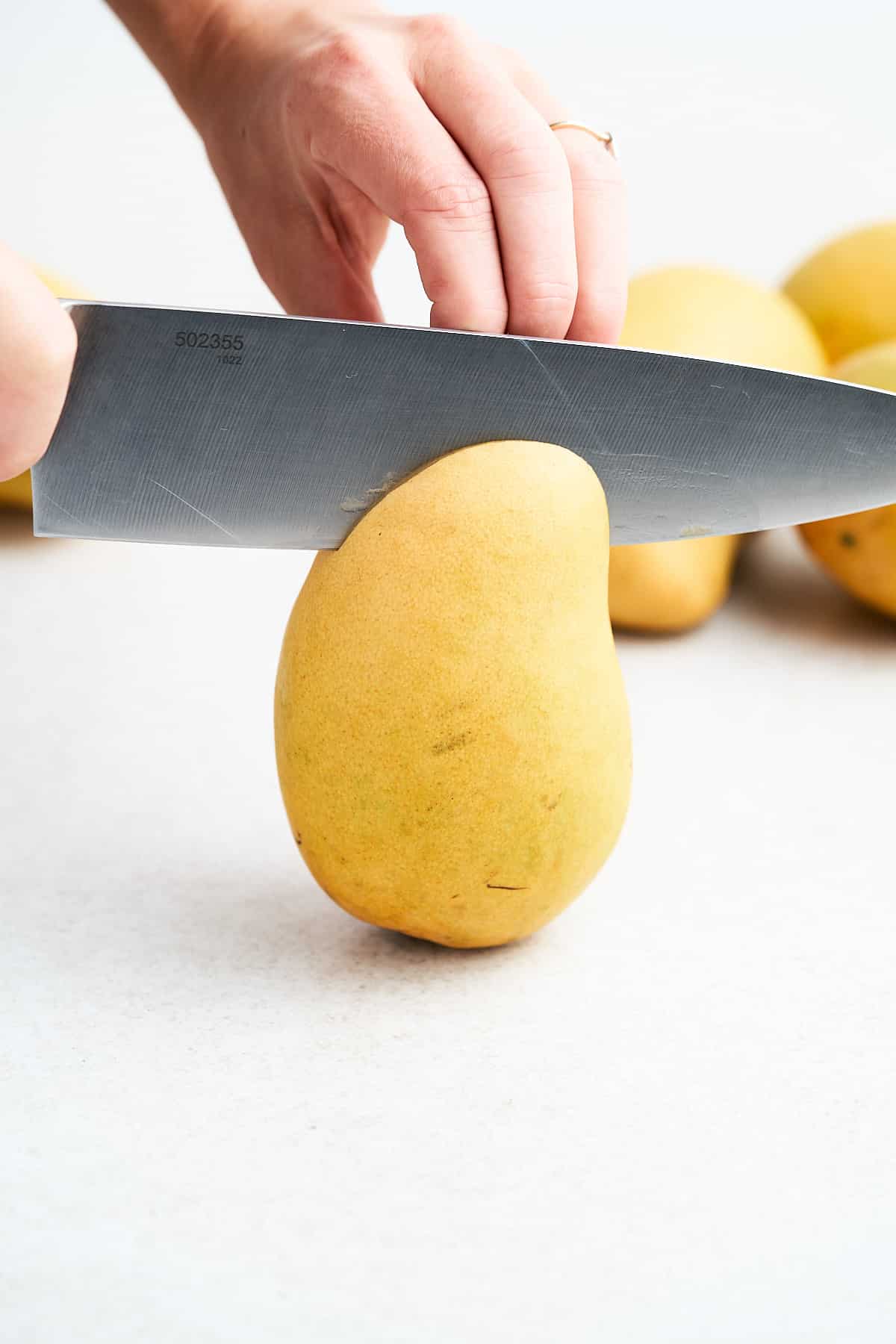 Cutting a mango lengthwise.