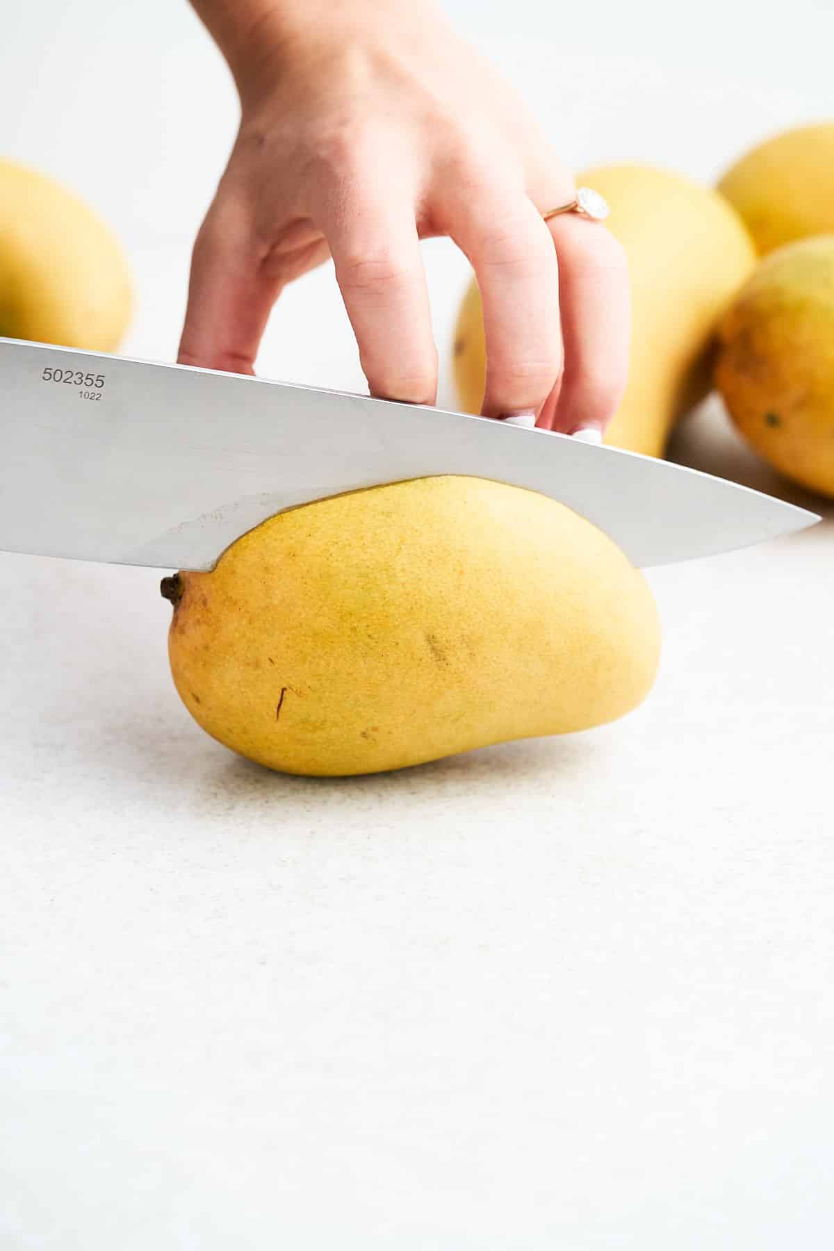 Cutting a mango on its side.