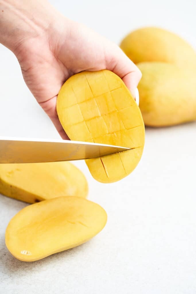 Slicing mango flesh crosswise.