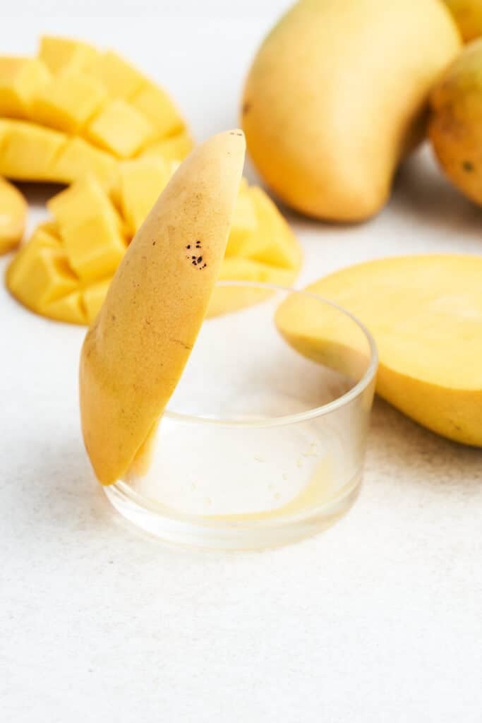 Mango sitting on the edge of a bowl.
