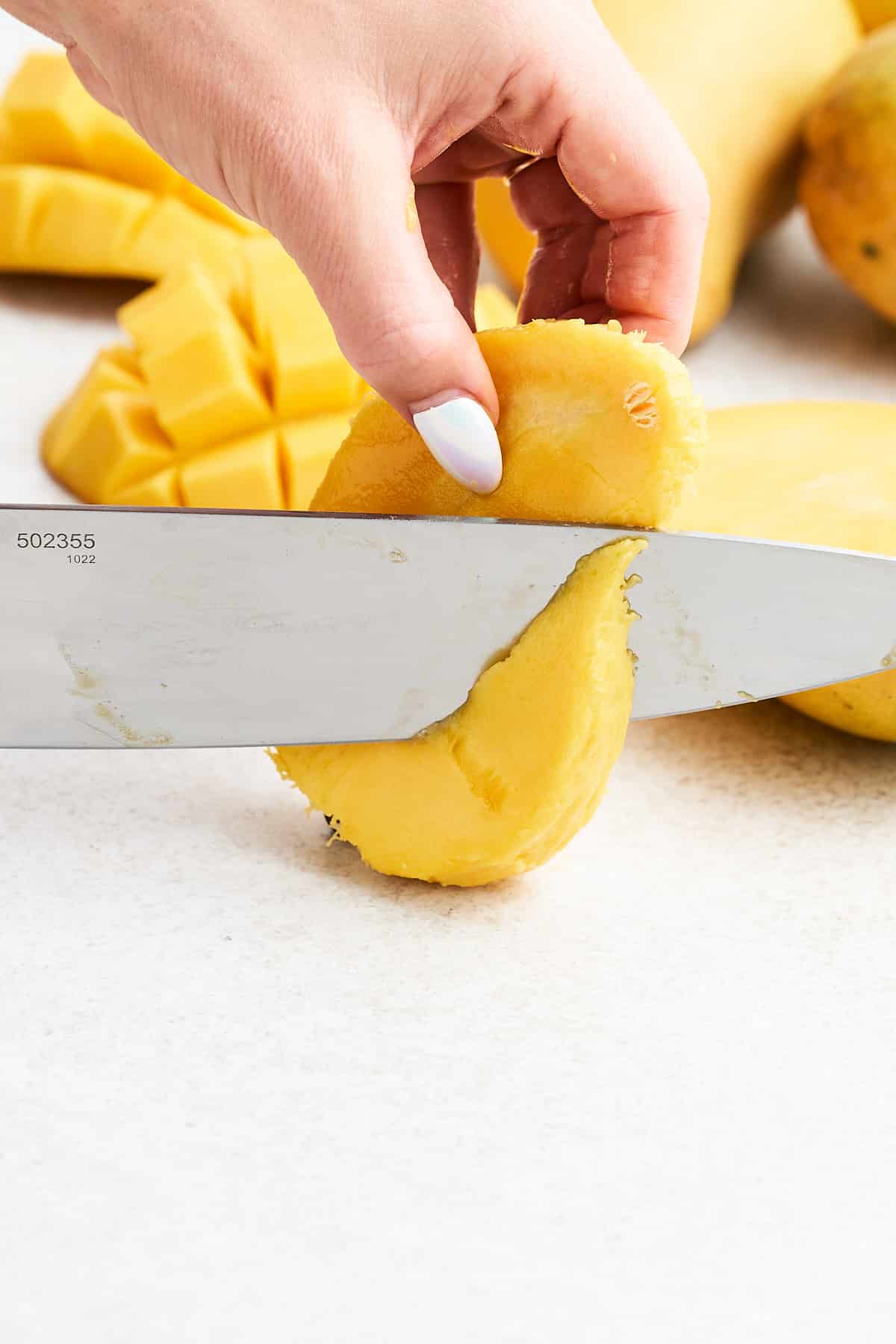 Slicing the flesh of a mango off the pit.