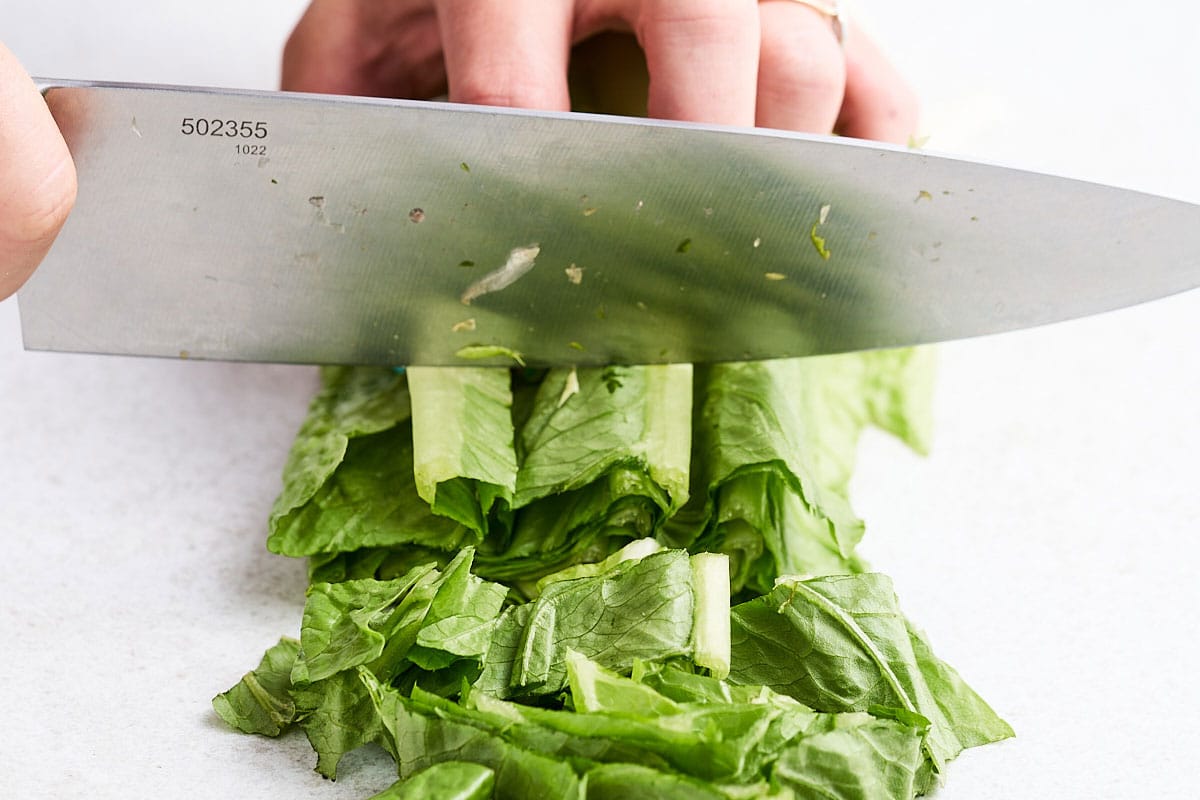 Cutting romaine lettuce into shreds.