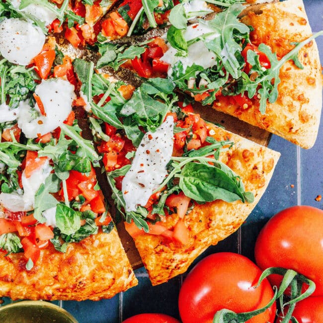 Bruschetta pizza on a tiled blue background.