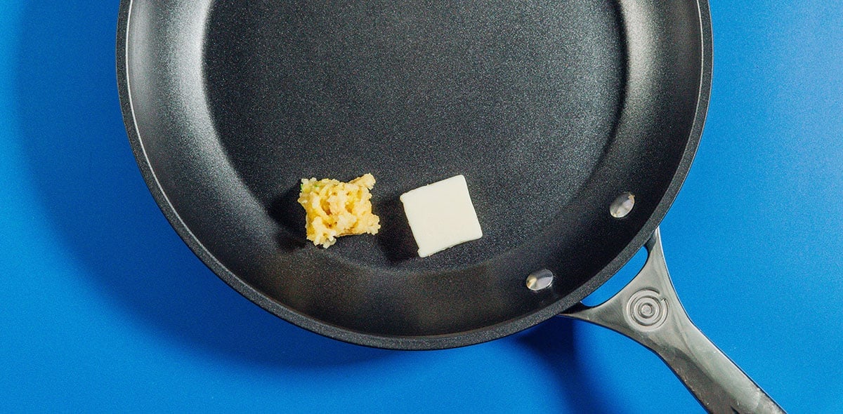 Butter and garlic in a black saute pan.