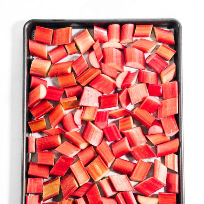 Close up of cut rhubarb on a baking sheet to freeze.