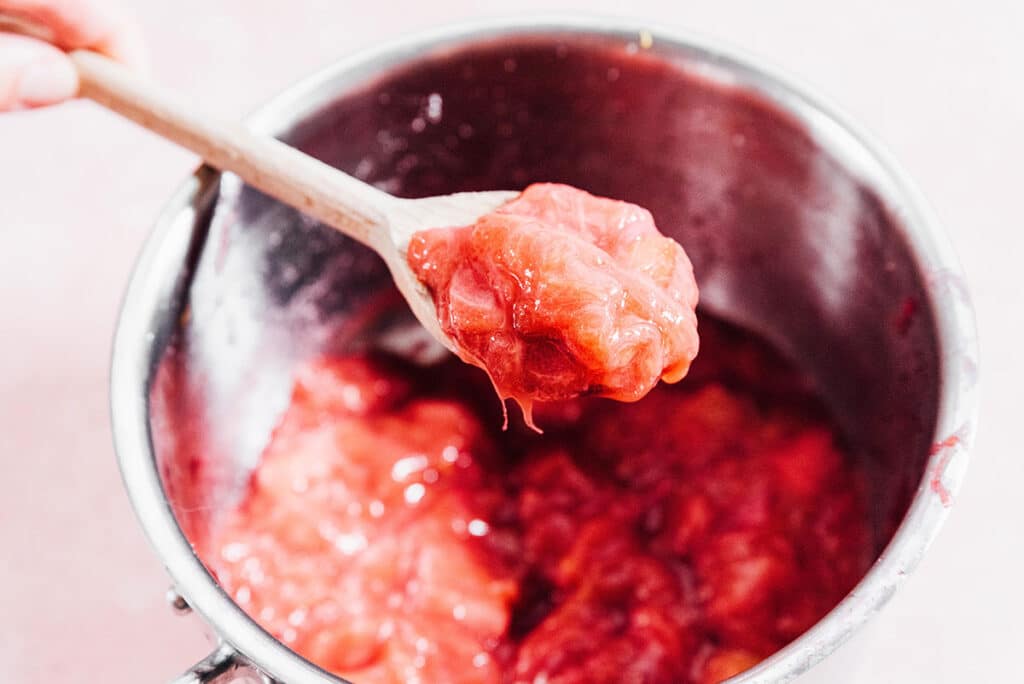 Rhubarb compote on a wooden spoon.